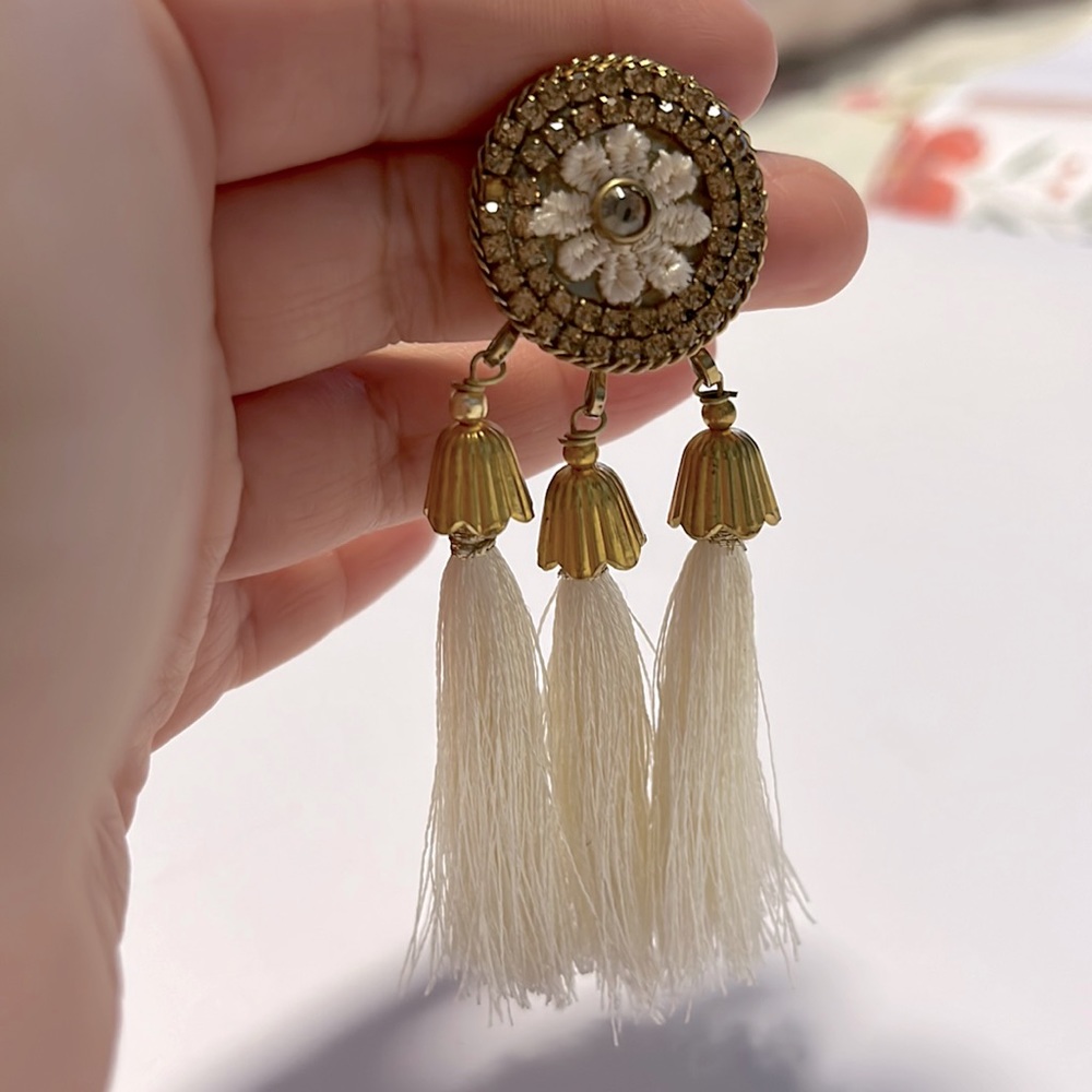cream long tassel earrings on gold